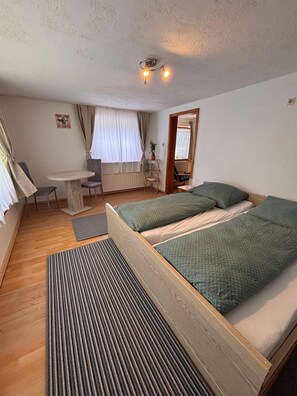 Ein Schlafzimmer mit zwei Betten, einem Schreibtisch und einem Stuhl.