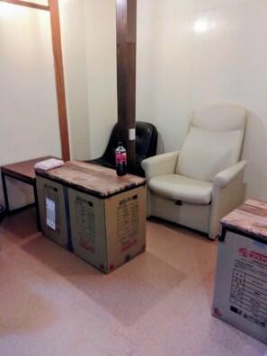 A room with a white chair, a small table, and two large cardboard boxes. - OKAYAMABACKPACKERS (Okayama)