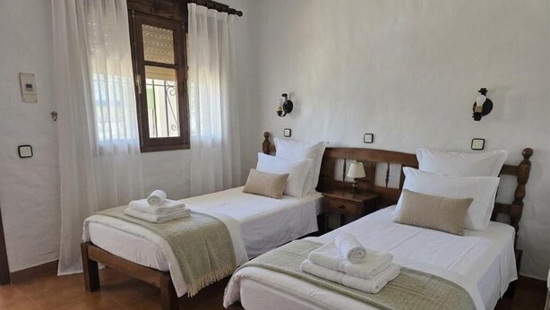 A hotel room with two single beds, a window with curtains, a wooden headboard, and bedside lamps. - Hotel Apolo XI (Tarifa)