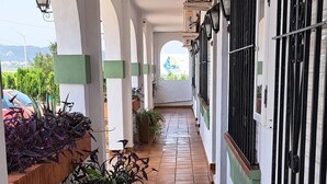A corridor with tiled flooring, potted plants, and a view of the outside. - Hotel Apolo XI (Tarifa)