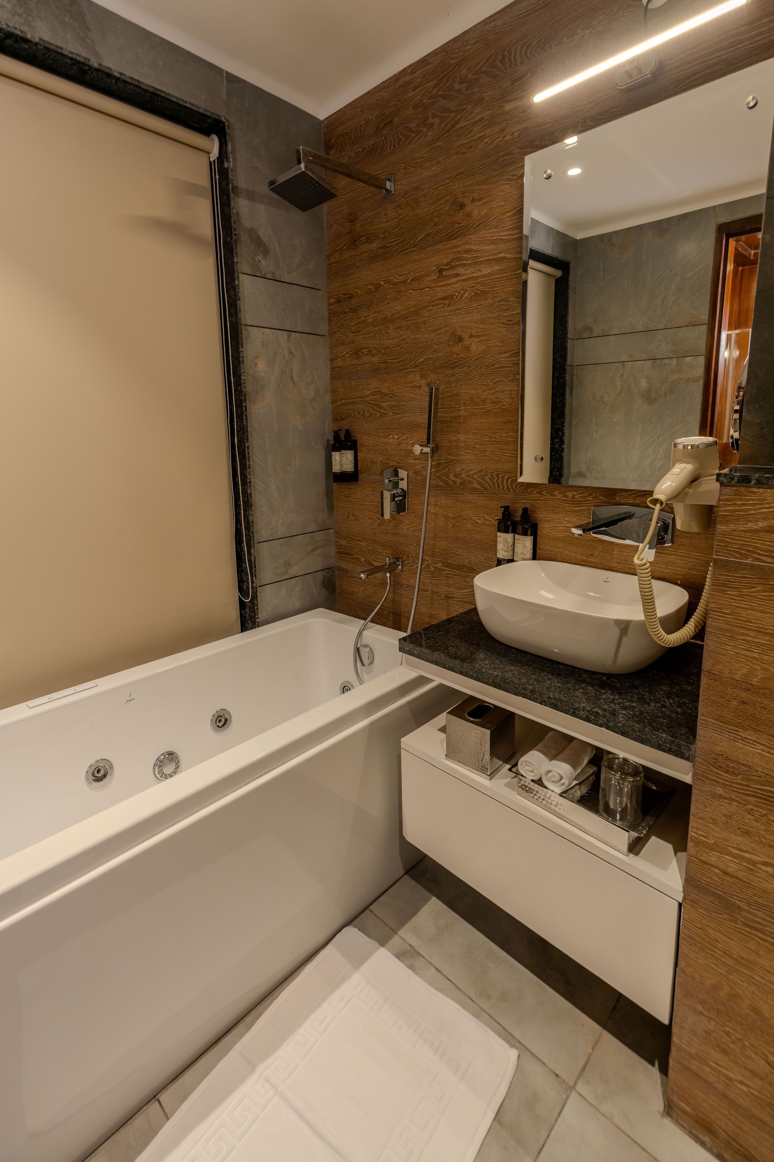 A modern bathroom with a freestanding bathtub, a vanity with a sink, and a large mirror.