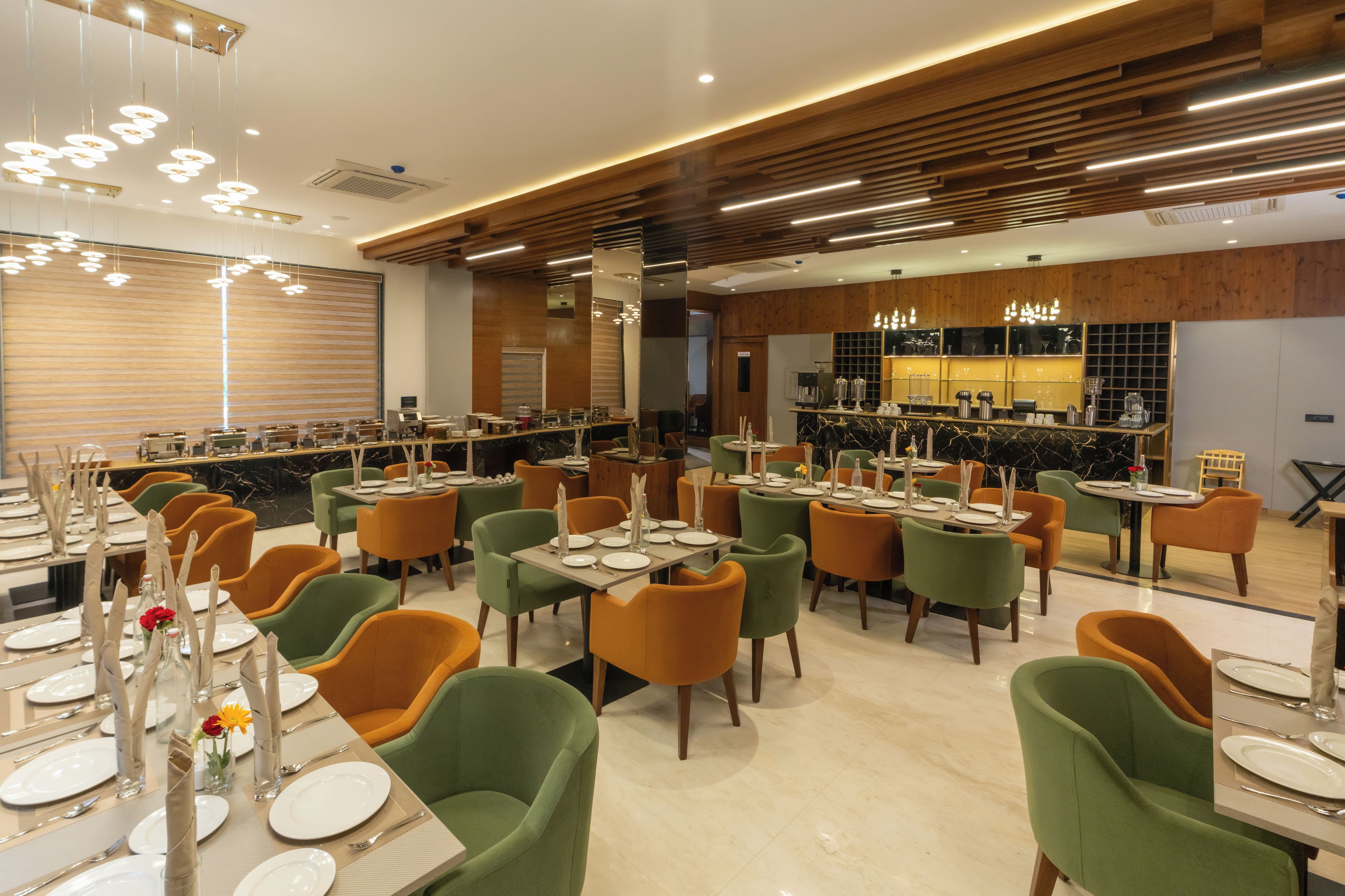 A restaurant with multiple dining tables, chairs, and a bar area.