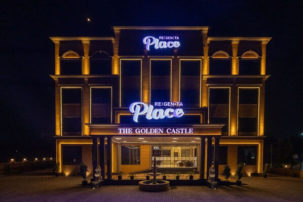 A hotel entrance with a marquee sign reading 'RE:GEN:TA Place THE GOLDEN CASTLE'.