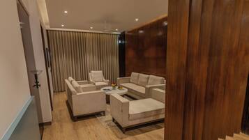 A modern living room with a sofa set, a coffee table, and a dining table.
