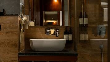 A modern bathroom with a large mirror, a white sink, and a glass shower enclosure.