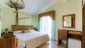 Quarto com cama, cabeceira de madeira, mesas de cabeceira, espelho e armário de madeira.