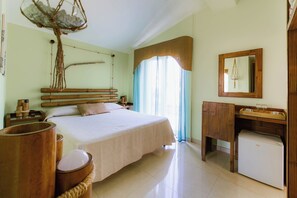 A bedroom with a bed, wooden headboard, bedside tables, a mirror, and a wooden cabinet.