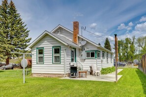 Einbungalow mit Schornstein, Satellitenschüssel und einer kleinen Veranda mit Tisch und Stühlen.