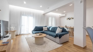 Una sala de estar moderna con un sofá, una mesa de centro y un televisor.