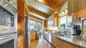 A kitchen with wooden cabinets, stainless steel appliances, and a granite countertop. - Private Mtn-View Pool! Rogue River Valley Escape (Eagle Point)