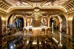 An opulent lobby with marble floors, ornate gold detailing, and a central bar area. - Arte Mont Kiara by Kuala Lumpur (Kuala Lumpur)