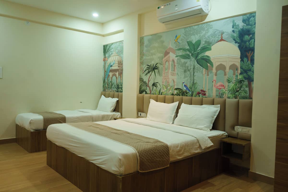 A hotel room with two beds, a mural on the wall, and a wooden floor.