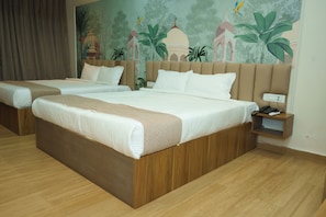A hotel room with two beds, a mural on the wall, and a nightstand with a phone.