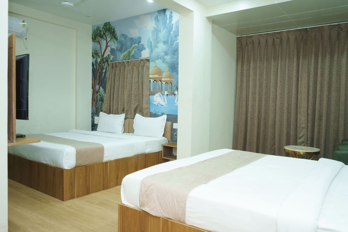 A hotel room with two beds, a mural on the wall, and a curtain.