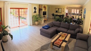Una sala de estar con sofá, mesa de centro y plantas en macetas.