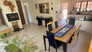 Un amplio salón con mesa de comedor, sillas, sofá y chimenea.