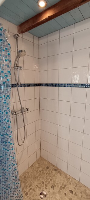 A shower with a tiled wall, a showerhead, and a shower curtain. - Countryside cottage, private terrace & garden overlooking walnut & plum orchards (Penne-d'Agenais)