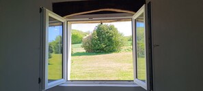 An open window with a view of a grassy field and a tree. - Countryside cottage, private terrace & garden overlooking walnut & plum orchards (Penne-d'Agenais)
