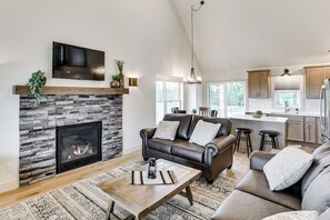 A living room with a fireplace, leather sofa, and a coffee table.