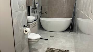 Apartamento superior, 3 quartos, vista para o pátio | Banheiro | Banheira e chuveiro separados, chuveiro com efeito de chuva