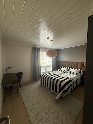 A bedroom with a bed, a desk, and a chair. - Premium 3BR Home with Prime Location (Helsinki)