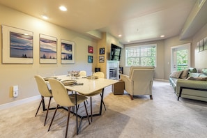Un coin repas avec une table, des chaises et des tableaux encadrés accrochés au mur.