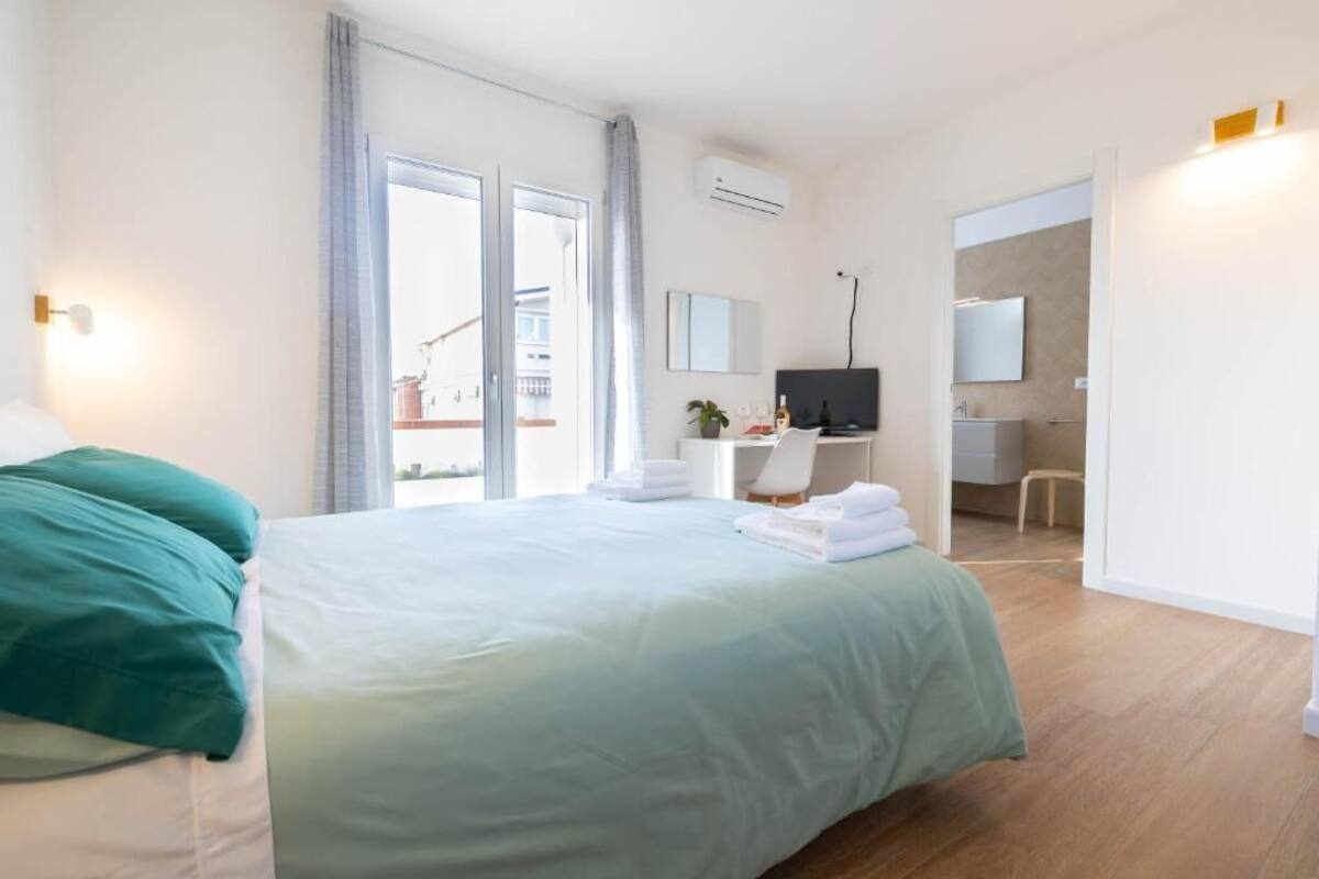 Ein Hotelzimmer mit Bett, Schreibtisch, Stuhl, Fernseher und Badezimmer.