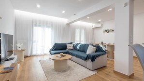 Una sala de estar moderna con un sofá, una mesa de centro y un televisor.
