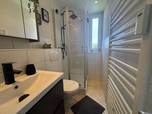 Ein modernes Badezimmer mit Dusche, Toilette und Waschbecken.