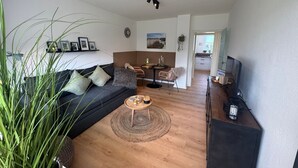 Ett modernt vardagsrum med en soffa, ett soffbord och ett TV-bord.