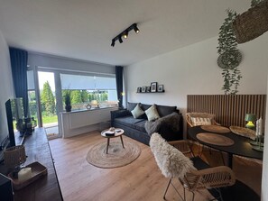 Ein modernes Wohnzimmer mit einer Couch, einem Couchtisch und einem Essbereich.