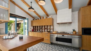Cocina moderna con armarios de madera, una isla central y suelo de baldosas.