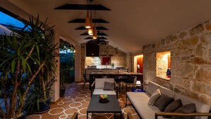 Un interior con comedor, sofá y plantas en macetas.
