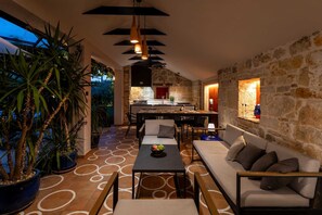 An interior with a dining area, sofa, and potted plants.