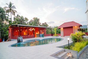 A pool area with a red building labeled 'Sorrento Cafe' and a smaller red-roofed structure. - Breeze Inn Beach Resort (Shrivardhan)
