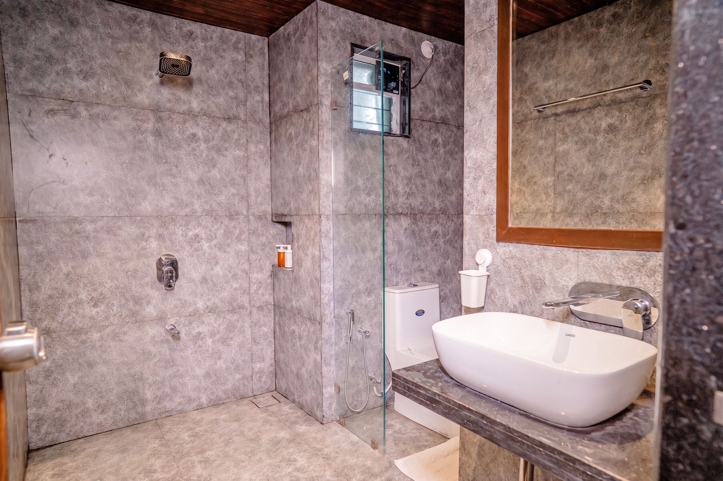 Une salle de bain avec douche, toilettes et lavabo.