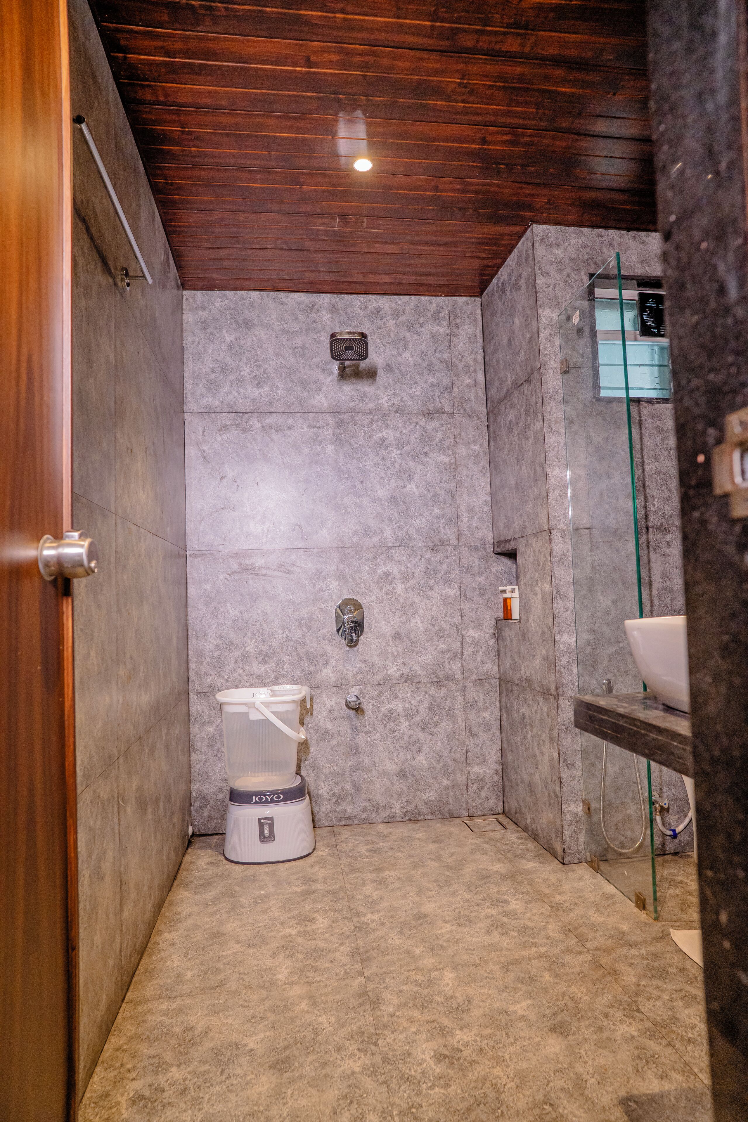 A bathroom with a toilet, a shower, and a sink.