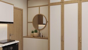 A modern kitchen with a built-in dishwasher, wooden cabinetry, and a round mirror above the countertop. - Urban Nest (Hanoi)
