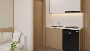 A compact kitchen with white cabinets, a black dishwasher, and a countertop with a sink. - Urban Nest (Hanoi)