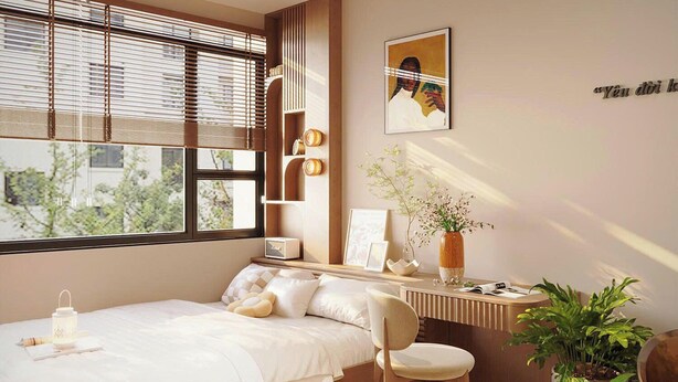A bedroom with a bed, a desk, a chair, a window with blinds, a painting, and a potted plant. - Urban Nest (Hanoi)
