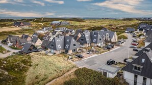 A residential area with modern houses, a main road, and a distant view of the sea. - Stylish vacation apartment for up to 4 people, close to the beach with balcony and (Hörnum (Sylt))