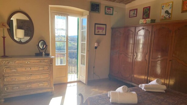 A bedroom with a bed, a dresser, a mirror, and a wardrobe. - Villetta in collina in Piemonte (Morsasco)