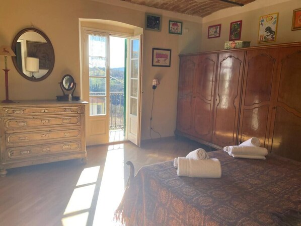 A bedroom with a bed, a dresser, a mirror, and a wardrobe.