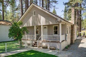 Ein eingeschossiges Haus mit Veranda, einem Steinkamin und einem umzäunten Garten.