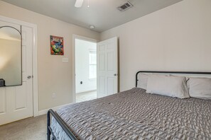 A bedroom with a bed, a door, and a poster on the wall. - 3 Mi to Dtwn! Houston Family Haven w/ Private Yard (Houston)