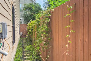 A wooden fence with climbing plants, a utility box, and a house in the background. - 3 Mi to Dtwn! Houston Family Haven w/ Private Yard (Houston)