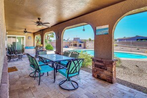 An outdoor patio with a table and chairs, a ceiling fan, and a view of a swimming pool. - 2 Mi to Windsor Boat Launch! Lake-View Escape (Lake Havasu City)