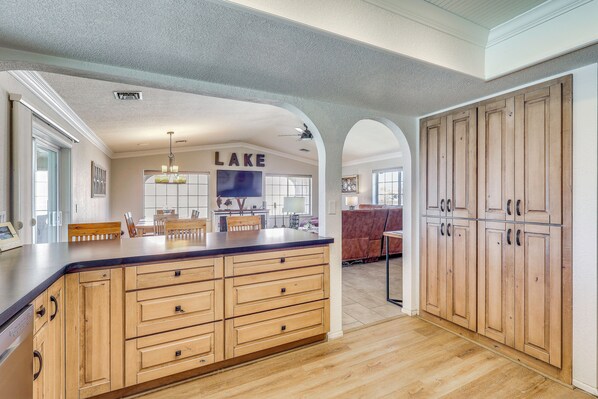 A kitchen with wooden cabinets, a large island, and a ceiling fan. - 2 Mi to Windsor Boat Launch! Lake-View Escape (Lake Havasu City)