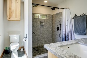Un baño con inodoro, ducha y lavabo.