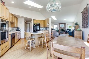 A spacious kitchen with wooden cabinets, a large island, and modern appliances. - < 1 Mi to Beach! Ocean-View Getaway in Freeland (Freeland)